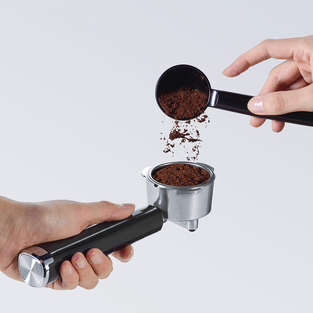 imagen café molido cucharilla traspasando a portafiltros cafetera