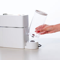 Mano cambiando el depósito de agua de una máquina de café